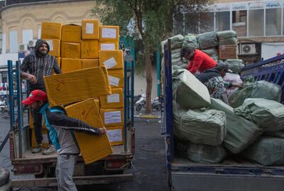 Workers load salvaged products from a sports supplies store onto trucks after the whole building caught fire during clashes between protesters and riot police. AP