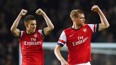Arsenal defenders Laurent Koscielny and Per Mertesacker shown after an Arsenal victory last season. Laurence Griffiths / Getty Images / November 2, 2013