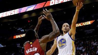 Golden State Warriors guard Stephen Curry, right, shoots over Miami Heat forward Udonis Haslem in the second half of an NBA basketball game, Tuesday, Nov. 25, 2014, in Miami. Golden State defeated the Heat 114-97. (AP Photo/Lynne Sladky)