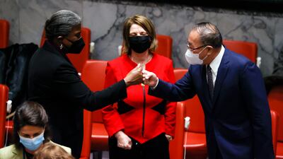 China's Mr Zhang bumps fists with Ms Thomas-Greenfield as Norway's Ms Juul watches. EPA