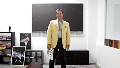 Ramin Salsali, founder of the Salsali Private Museum in Al Quoz, Dubai, in his office at the museum, which opens tonight. The painting he is holding is Papi, by his son Douglas, 10.