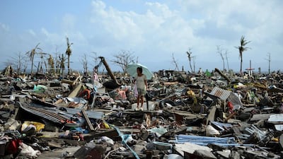 A survivor walks among the debris of houses destroyed by typhoon Haiyan in Tacloban, the Philippines. Noel Celis / AFP