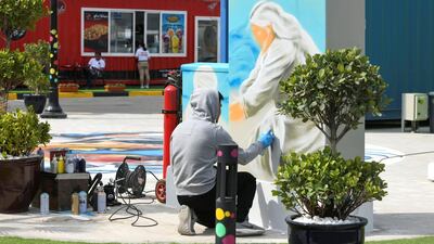 A graffiti artist finishes up a piece at the grand opening of Marsa Mina. Khushnum Bhandari for The National