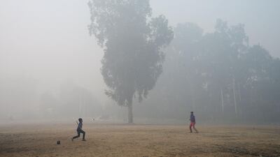 Indian children play a game in a field amid dense fog and air pollution in Jalandhar. Shammi Mehra / AFP Photo