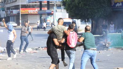 A wounded man is carried during the clashes with Israeli troops. EPA