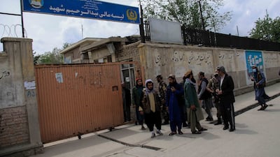 Taliban fighters gather outside the school. In May 2021, at least 85 people – mostly children – were killed in a bombing at another school in the area. EPA