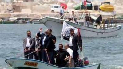 The Gazan prime minister Ismail Haniyeh, waving, rides a boat off Gaza City's coast yesterday in preparation for the flotilla's arrival.
