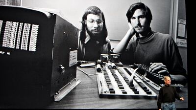 FILE: Steve Jobs, chief executive officer of Apple Inc., right, speaks in front of a file photograph of himself and Apple co-founder Steve Wozniak during the launch of the Apple iPad in San Francisco, California, U.S., on Wednesday, Jan. 27, 2010. Jobs, w???