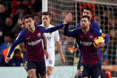 Philippe Coutinho has played in more advanced positions, alongside Lionel Messi, right, and Luis Suarez. Alberto Estevez / EPA