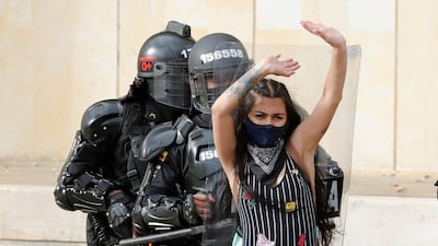 A demonstrator protects members of the Mobile Anti-Riot Squad during an anti-government demonstration near the Plaza de Bolivar in Bogota, Colombia. EPA