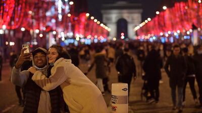 A couple takes a selfie picture along the Champs-Elysees on New Year's Eve. AFP