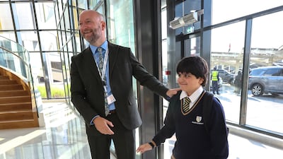 Mr Ian Pugh, principal of Muna British Academy, greets a pupil on the first day of classes