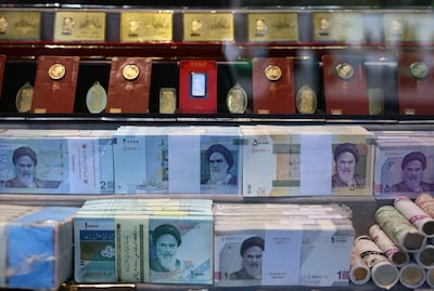 Banknotes and gold coins on display in a bazaar in Tehran. Many Iranians are buying dollars, gold and property to try to preserve their wealth. EPA