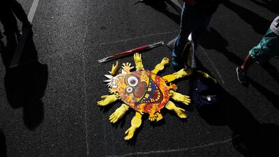Participants stand next to a stylised virus symbol during a protest against coronavirus pandemic regulations in Berlin, Germany. EPA