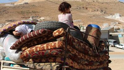 Syrian refugee children ride on a vehicle getting ready to cross into Syria from the eastern Lebanese border town of Arsal, Lebanon, on June 28, 2018. Stringer / AFP