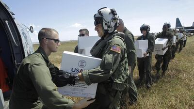 US military personnel load relief aid on to a helicopter from the USS George Washington carrier at a landing zone a the airport in Tacloban on Friday. Wally Santana / AP Photo
