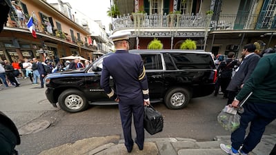 A French military aide stands by as Mr and Ms Macron walk through the French Quarter. AP