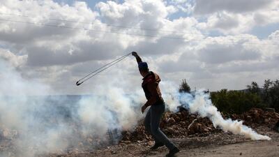 A young Palestinian protester prepares to fire a slingshot during clashes with Israeli soldiers following a weekly demonstration against the expropriation of Palestinian land by Israel in the village of Kfar Qaddum, near Nablus, in the occupied West Bank, on March 16, 2018. Jaafar Ashtiyeh / AFP