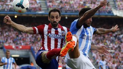 Atletico Madrid player Juanfran and Malaga player Samuel Garcia fight for the ball during their La Liga match on Sunday. Sergio Perez / Reuters