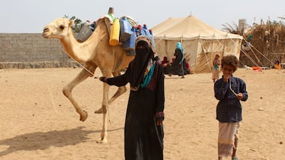 A displaced woman and child who fled from the western coastal city of Hodeidah due to the ongoing civil war between the Saudi-backed government and Houthi rebels, walk leading a camel at a make-shift camp following their arrival in Aden. Saleh Al-Obeidi / AFP