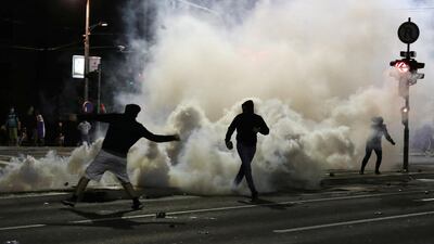 Demonstrators are seen amid tear gas during a protest outside the Serbian parliament in Belgrade. Reuters