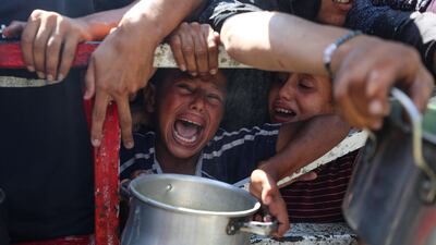 Palestinians wait to receive food from a charity kitchen in Gaza City. Reuters