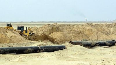 Pipes are put in place as the land is cleared at Iraq's Majnoon oilfield, where the government is blaming Shell for production shortfalls. Ali Al Saadi / AFP