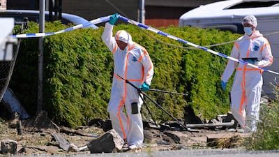 Forensics officers inspect the crash site. AFP