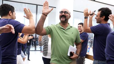 Ranjit Jose, the second customer, gets high fives from the Apple store staff at Mall of the Emirates in Dubai. Pawan Singh / The National