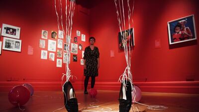 A woman poses amongst shoes suspended by balloons during a press preview of the exhibition "Michael Jackson: On the Wall" at the National Portrait Gallery in London, Britain, on June 27, 2018. Neil Hall / EPA