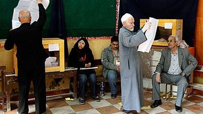 A voter inspects a list of candidates before voting in the Shubra neighbourhood of Cairo yesterday.