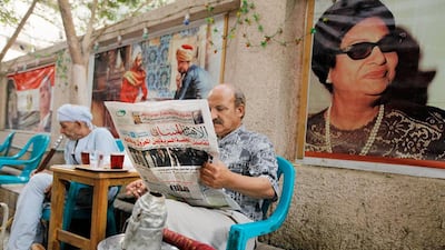 An Egyptian man reads the daily Al-Ahram newspaper at a coffee shop in Cairo, Egypt. AP
