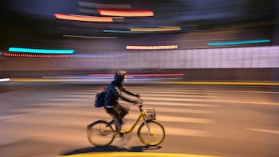 A person wearing a face mask rides a bicycle on a street in Shanghai. AFP