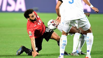 Egypt's forward Mohamed Salah loses his footing after a challenge from a DR Congo player. EPA