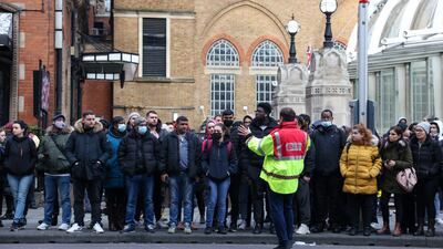 An employee from Transport for London directs commuters waiting for buses near Liverpool Street station. Bloomberg