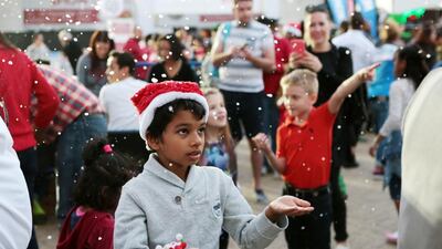 Paul Thierry, 8, reacts to artificial snow falling from a machine during the Dubai Winter Festival at the World Trade Centre in Dubai. (Christopher Pike / The National)