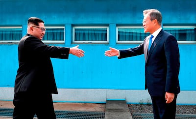 North Korean leader Kim Jong Un prepares to shake hands with South Korean President Moon Jae-in over the military demarcation line between the countries on April 27, 2018. (AP, pool)