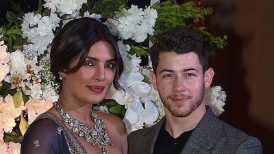 Indian Bollywood actress Priyanka Chopra (L) and US musician Nick Jonas, who were recently married, pose for a picture during a reception in Mumbai / AFP / Sujit Jaiswal