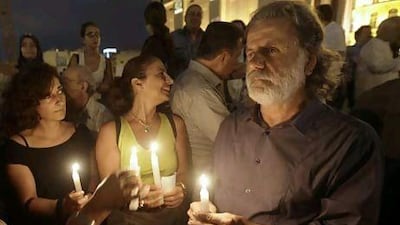 The Lebanese singer Marcel Khalifa, right, holds a candle during a vigil sit-in by Lebanese intellectuals and journalists to show their support to the Syrian protesters.