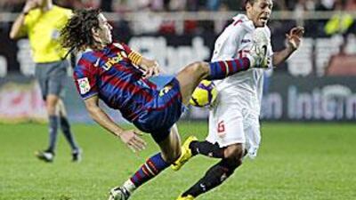 Barcelona's Carles Puyol, left, goes in high on Sevilla's Adriano during Wednesday's match.