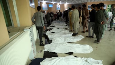 Afghan men try to identify bodies at a hospital after a deadly bomb explosion near a school west of Kabul. AP