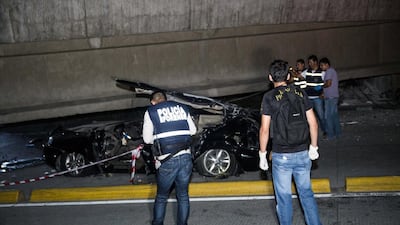 Police look at a car crushed under a collapsed overpass in Guayaquil, Ecuador. Jeff Castro / AP Photo