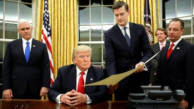 Rob Porter and President Donald Trump in the Oval Office. Mr Porter's former wives recounted physical, verbal and emotional abuse they say he subjected them to during their marriages. Jonathan Ernst / Reuters