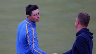 Team USA's Justin Thomas shakes hands with Team Europe's Viktor Hovland on the 18th green after halving the match during the Four-balls. Reuters