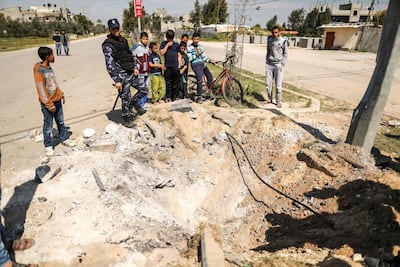 A member of the Hamas security forces inspects the crater left at the site of an explosion that targeted the convoy of the Palestinian prime minister during his visit to the Gaza strip, near the Erez crossing, in Beit Hanun, on March 13, 2018. Mahmud Hams / AFP