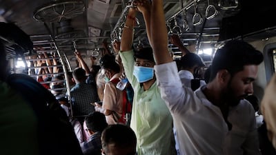 Indian commuters, some wearing protective masks as a precaution against Covid-19, travel in a crowded local train in Mumbai, India. AP Photo