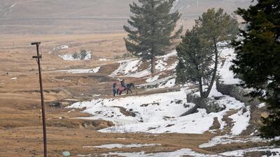 A tourist rides through patches of snow in Gulmarg on January 25, days before the ski resort in India's Kashmir region received its first proper snowfall of the winter season. AP Photo