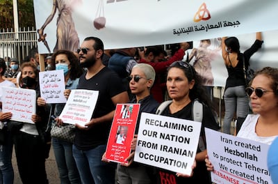 Protestors from the Lebanese opposition front carry placards shout slogan against Hezbollah during a protest in front of the Justice Palace in Beirut, Lebanon, 19 October 2021. EPA