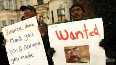 Activists Mohamed Suleiman, right, and Khalid Gerais posters as they protest in front of the Sudanese Embassy in Washington.