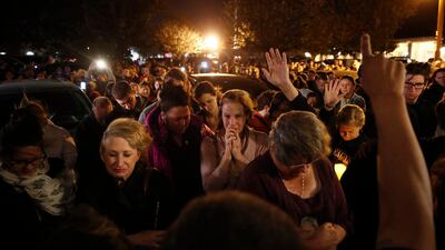 People gather outside the Rivalry Roasters for a vigil for Adler. AP Photo